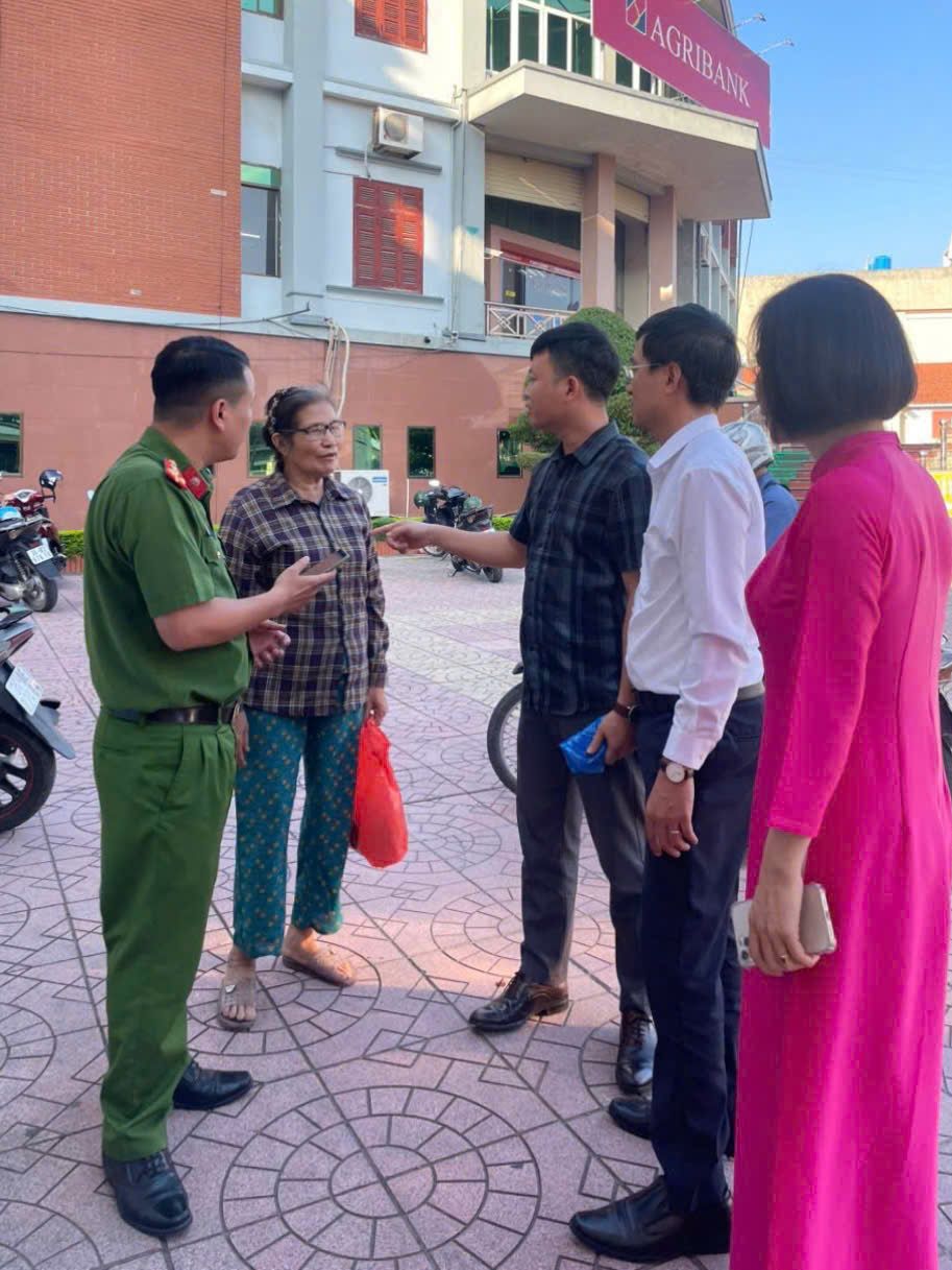 Bà Phiếu (xách túi đỏ) được nhân viên ngân hàng và cán bộ Công an xã Thanh Miện giải thích, tuyên truyền về thủ đoạn lừa đảo chiệm đoạt tài sản qua mạng. Ảnh Báo Công an Hải Phòng